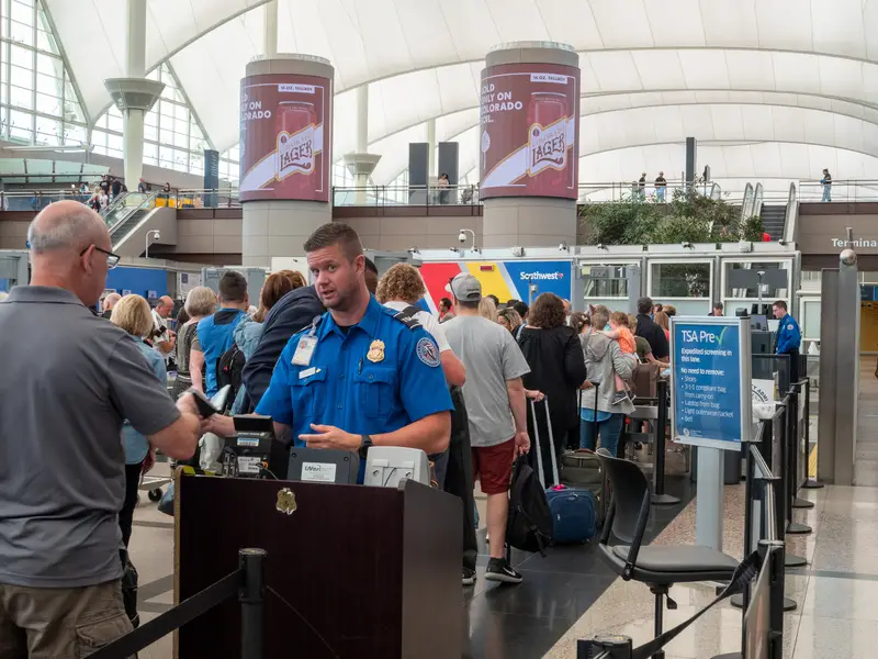 TSA agent passes man through security checkpoint at Denver International Airport