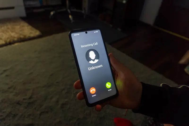 Woman holding mobile phone with incoming call from unknown caller